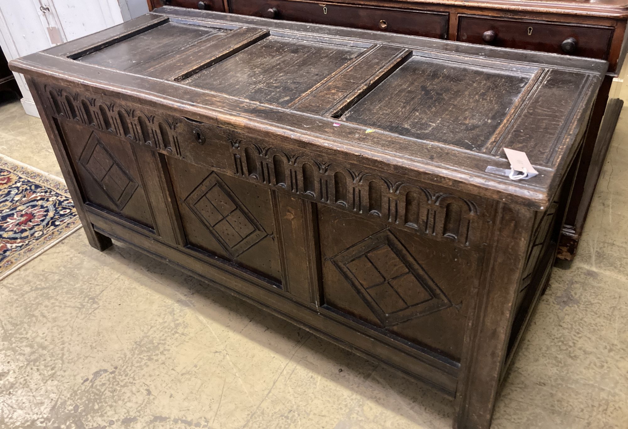 An 18th century oak coffer, later carved, width 135cm, depth 59cm, height 64cm